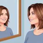 A woman with shoulder-length, layered hair smiles as she looks in the mirror, pleased with her youthful and flattering haircut